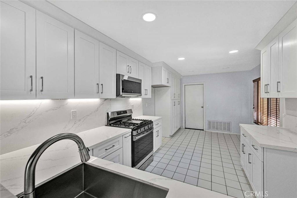 Modern Kitchen with White Cabinets and Tile Floor in Real Estate Listing
