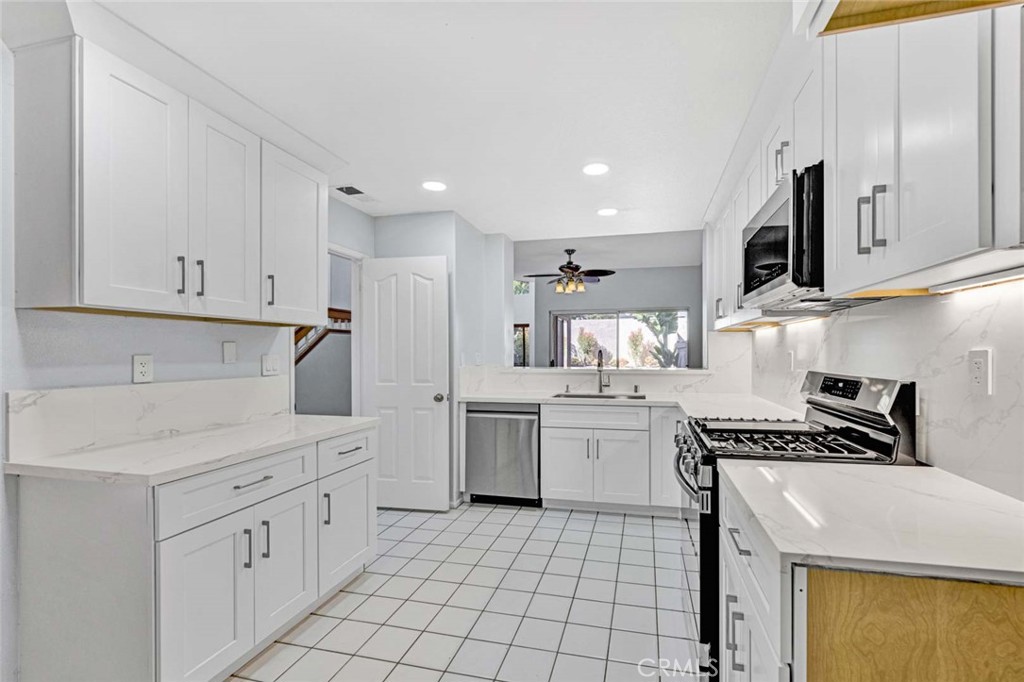 Modern Kitchen with White Cabinets and Stainless Steel Appliances in Real Estate Listing