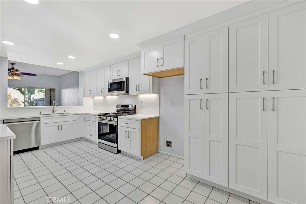 Modern White Kitchen with Ample Cabinets and Stainless Steel Appliances