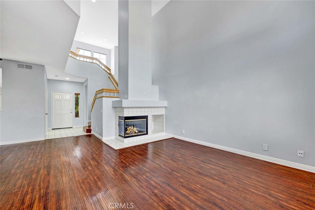 Spacious Living Room with Hardwood Floors and Modern Fireplace in Real Estate Listing