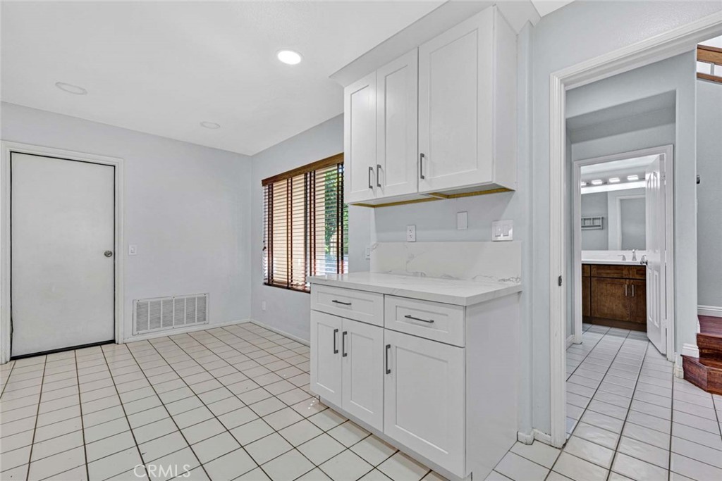 Spacious Kitchen with White Cabinets and Tile Floor in Homes for Sale