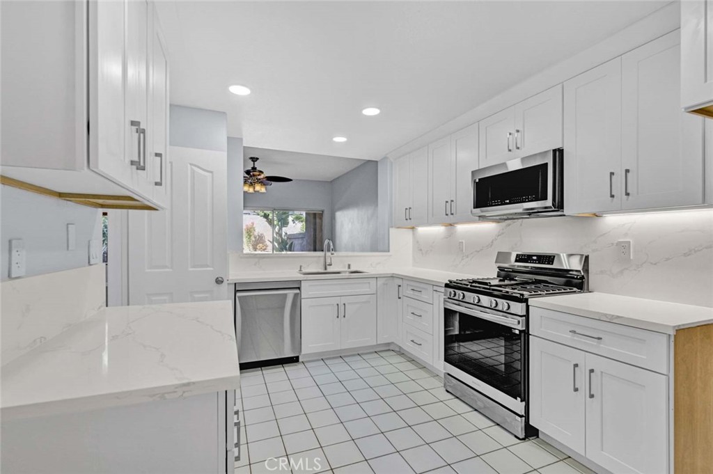 Modern Kitchen with White Cabinets and Stainless Steel Appliances in Real Estate Listing