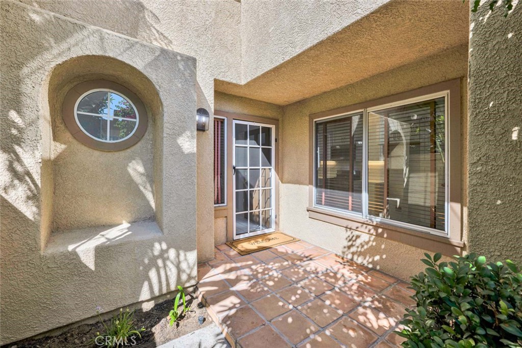 Stucco Home Exterior with Circular Window and Outdoor Tile Patio Real Estate