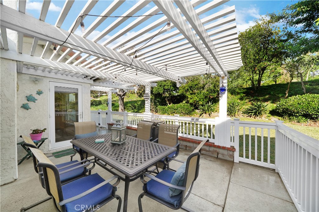 Sunny Patio with Pergola and Outdoor Dining Set in Residential Backyard