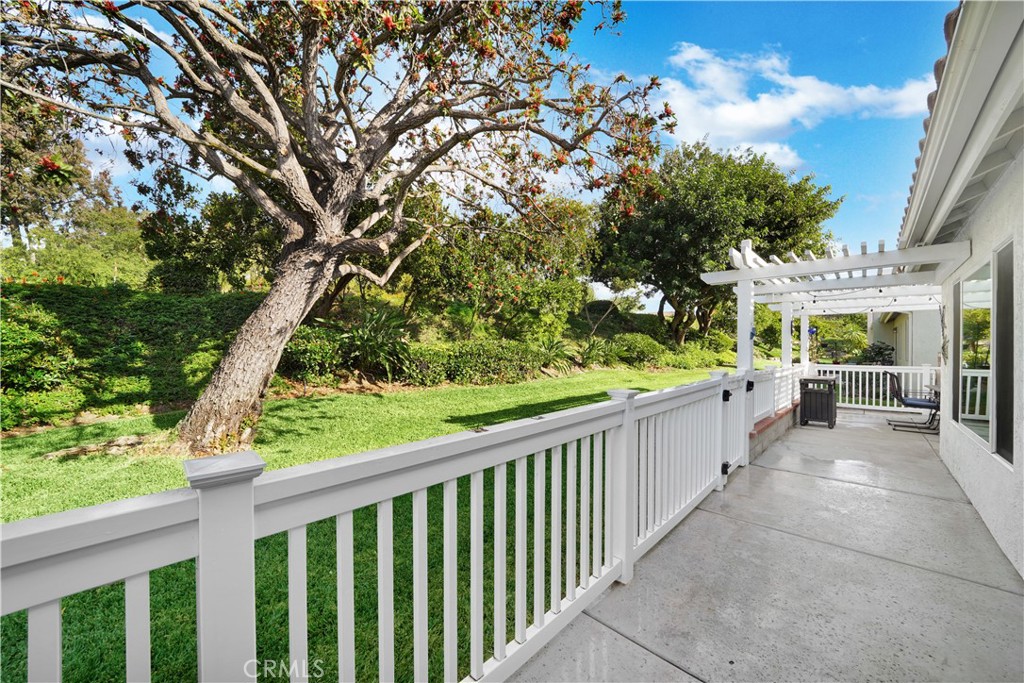 Spacious Backyard with Lush Greenery and White Fence in Real Estate Listing
