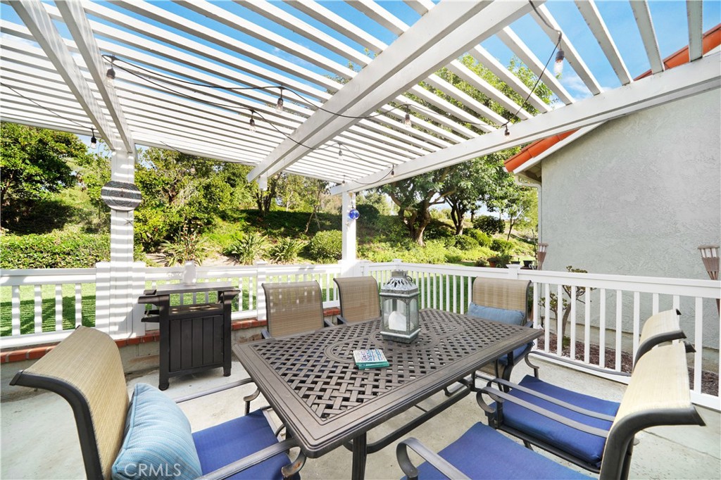 Spacious Patio with Dining Set Under Pergola in Real Estate Listing
