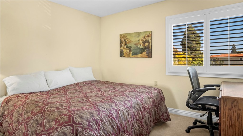 Bedroom With Double Bed, Office Chair, and Window Overlooking Trees