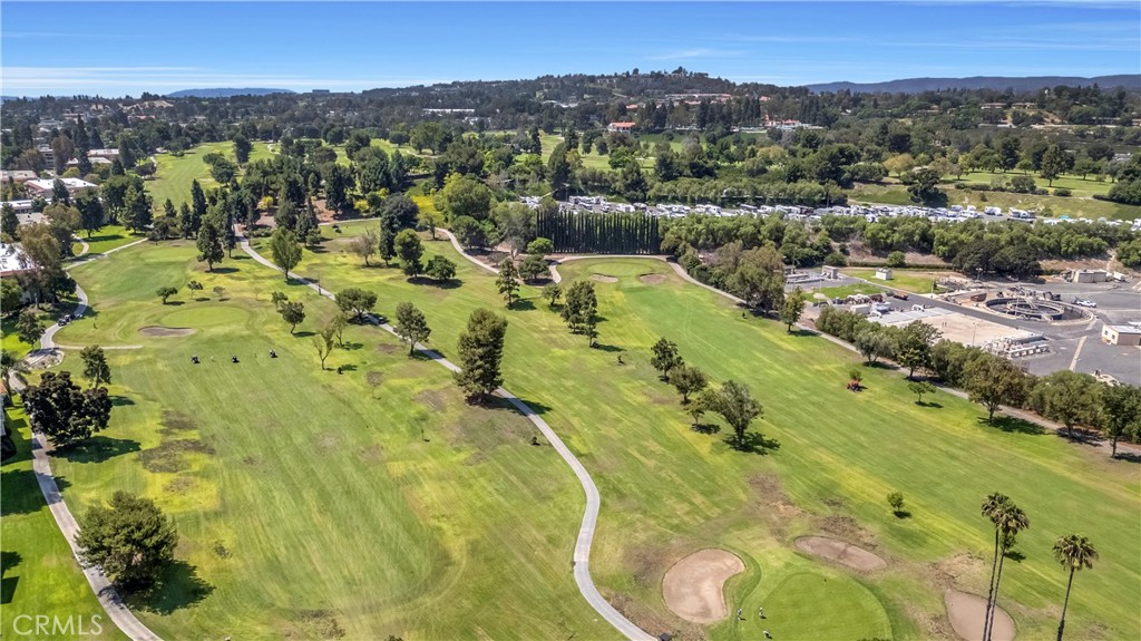 Expansive Golf Course With Surrounding Greenery and Distant Real Estate Listings
