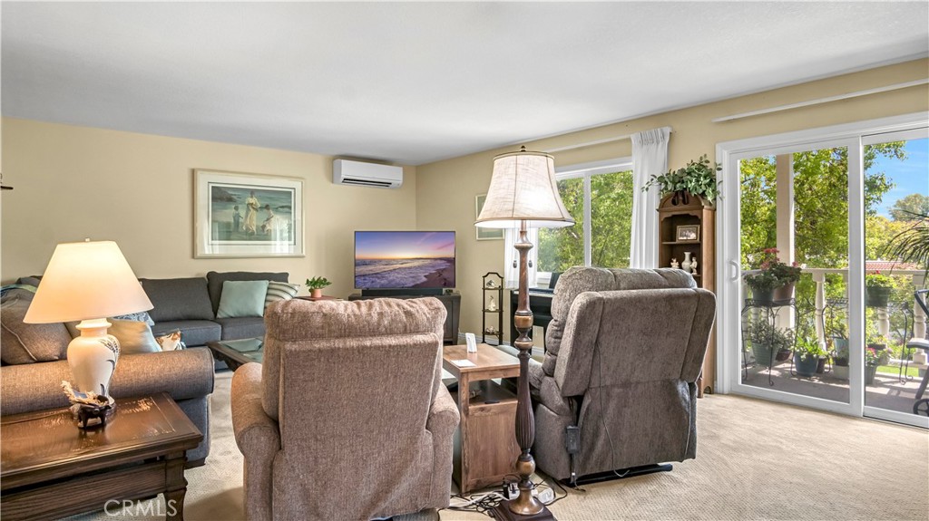 Spacious Living Room with Cozy Furniture and Large Balcony in Real Estate Listing