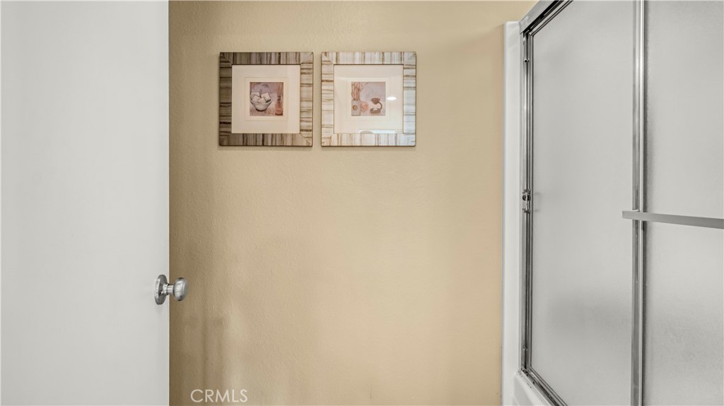 Bathroom Interior with Framed Artwork on Beige Wall Near Shower Door