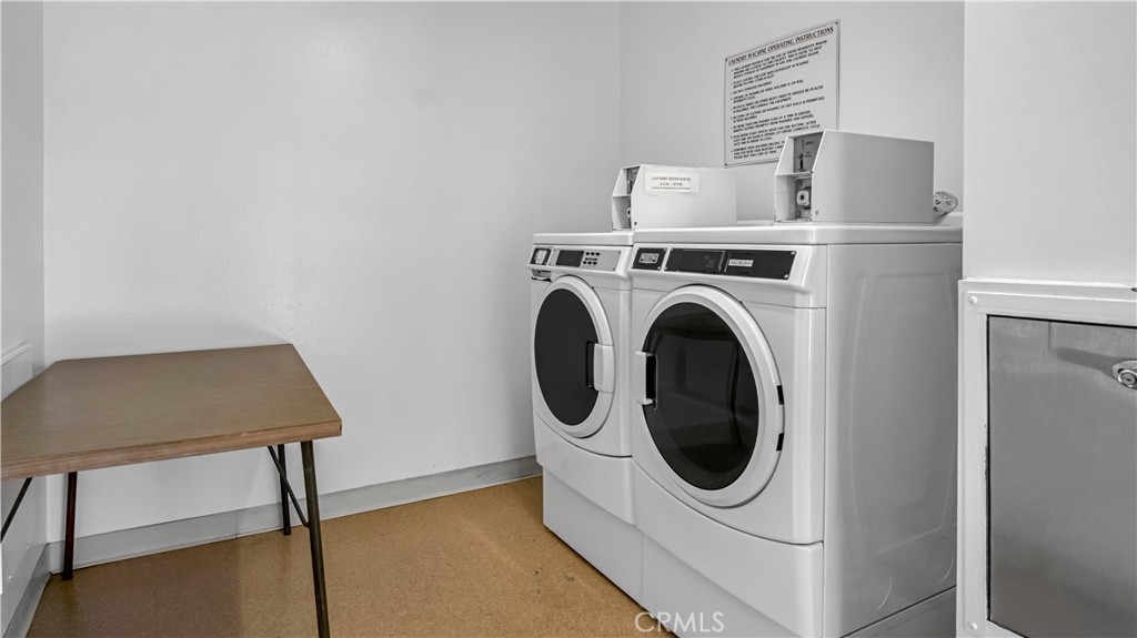 Laundry Room with Washer, Dryer, and Folding Table in Real Estate Listing