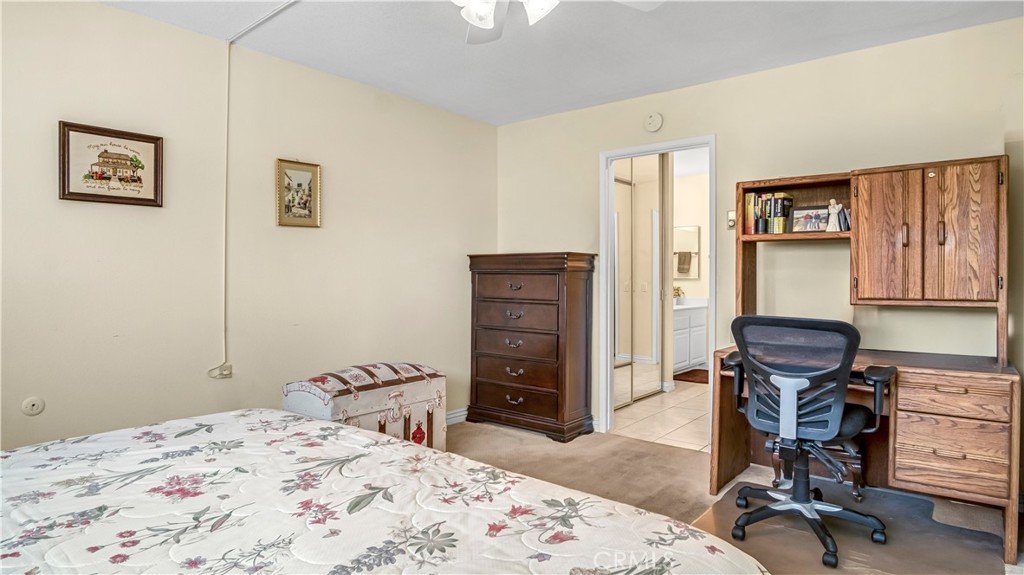 Bedroom with Bed, Desk, Chair, and Chest of Drawers in Real Estate Listing