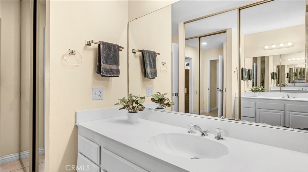 Spacious Bathroom with Double Sink Vanity and Large Mirror Reflecting Closet