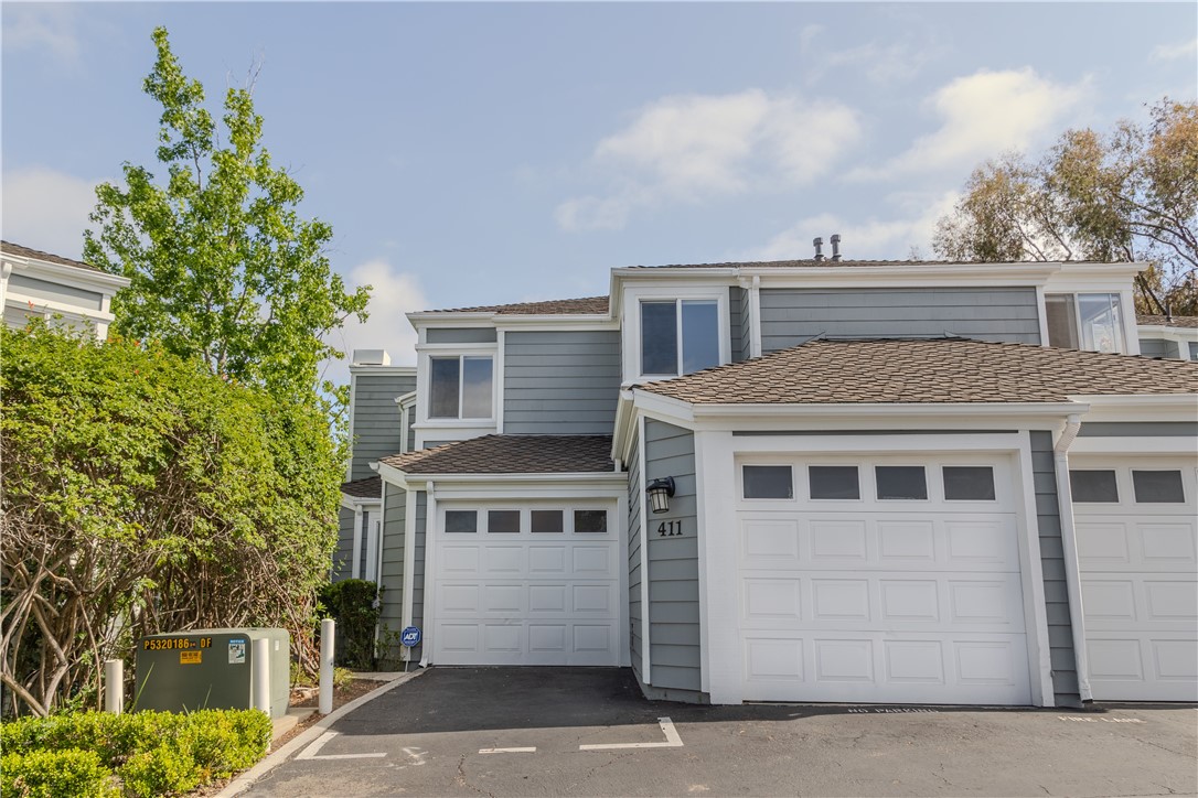 Two-Story Gray House with Garage and Lush Greenery, Real Estate Listing