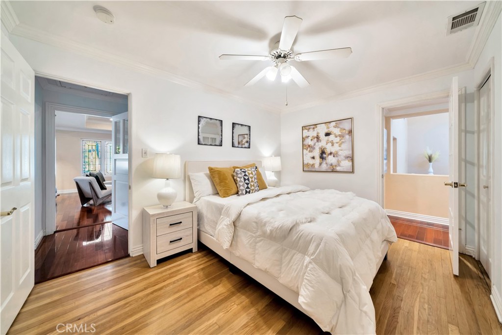 Bright Bedroom with Wooden Floor and Elegant Decor in Real Estate Listing