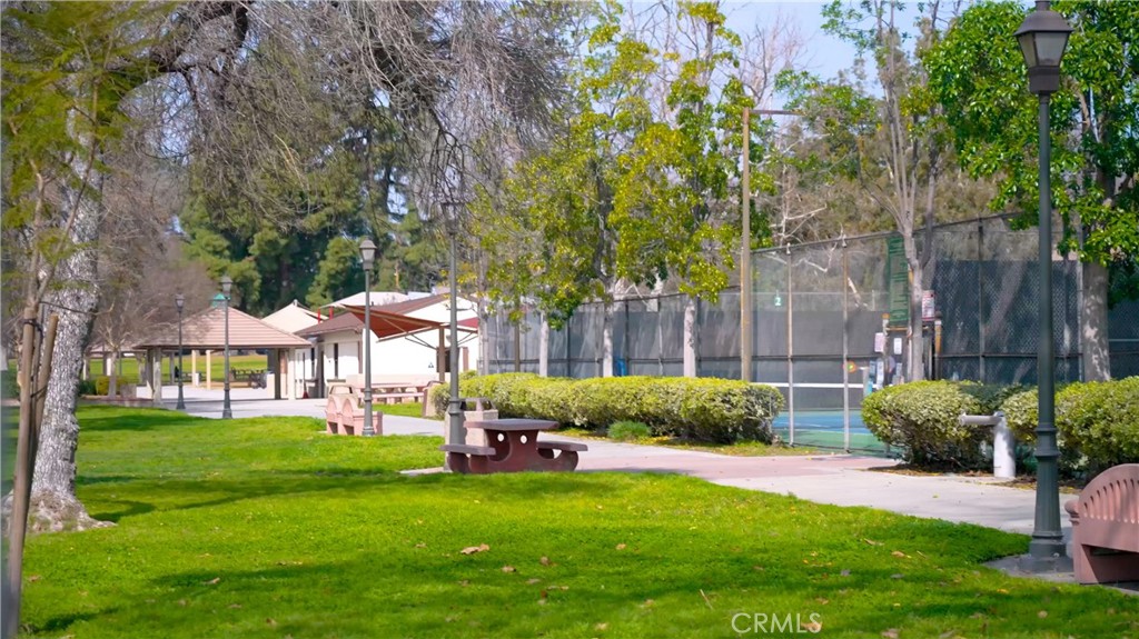 Park Pathway with Benches and Tennis Court Near Real Estate Listings