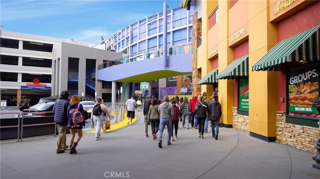 People Walking Near Shops and Parking Garage in Urban Real Estate Area
