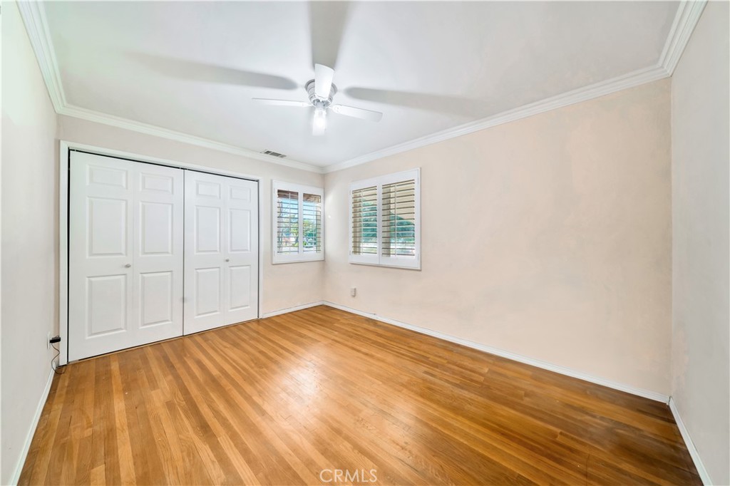 Spacious Empty Room with Hardwood Floors and Ceiling Fan in Real Estate Listing