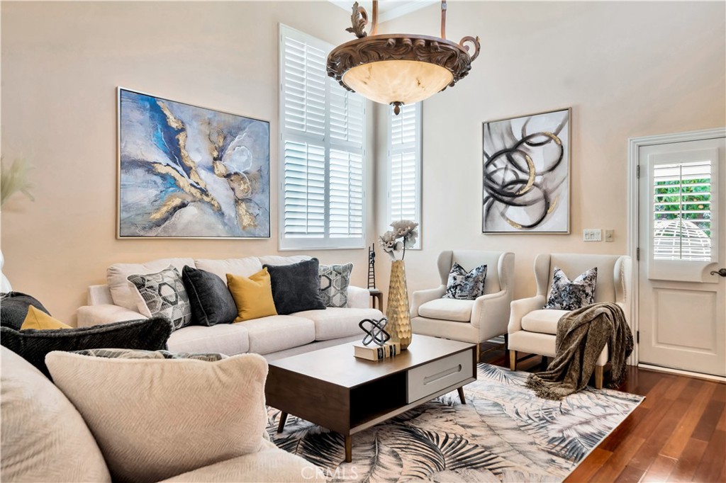 Bright living room with white sofa, wall art, and pendant lighting