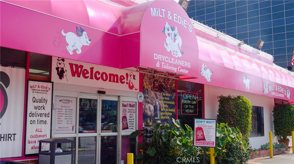 Pink Dry Cleaners Storefront with Welcome Sign and Open Notice