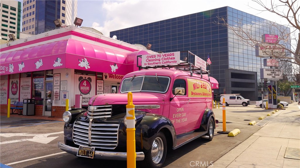 Pink Retro Truck Parked Outside 24-Hour Laundry Service Near Modern Buildings