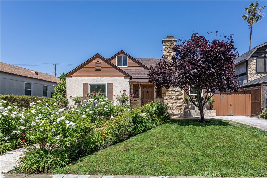 Charming Bungalow Style Home with Lush Garden and Stone Chimney