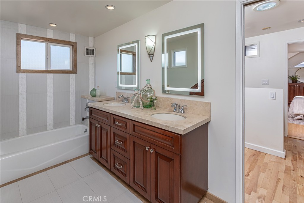 Modern Bathroom with Dual Vanities and Wooden Cabinets in Real Estate Listing