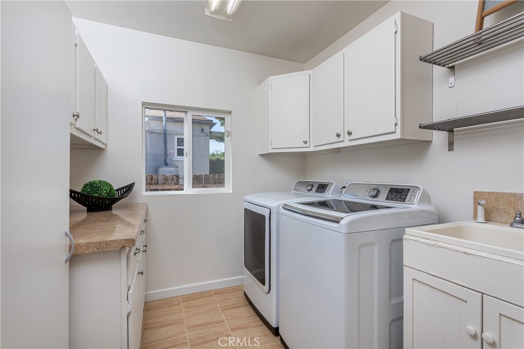 Laundry Room with Washer, Dryer, and Storage Cabinets in Real Estate Listing