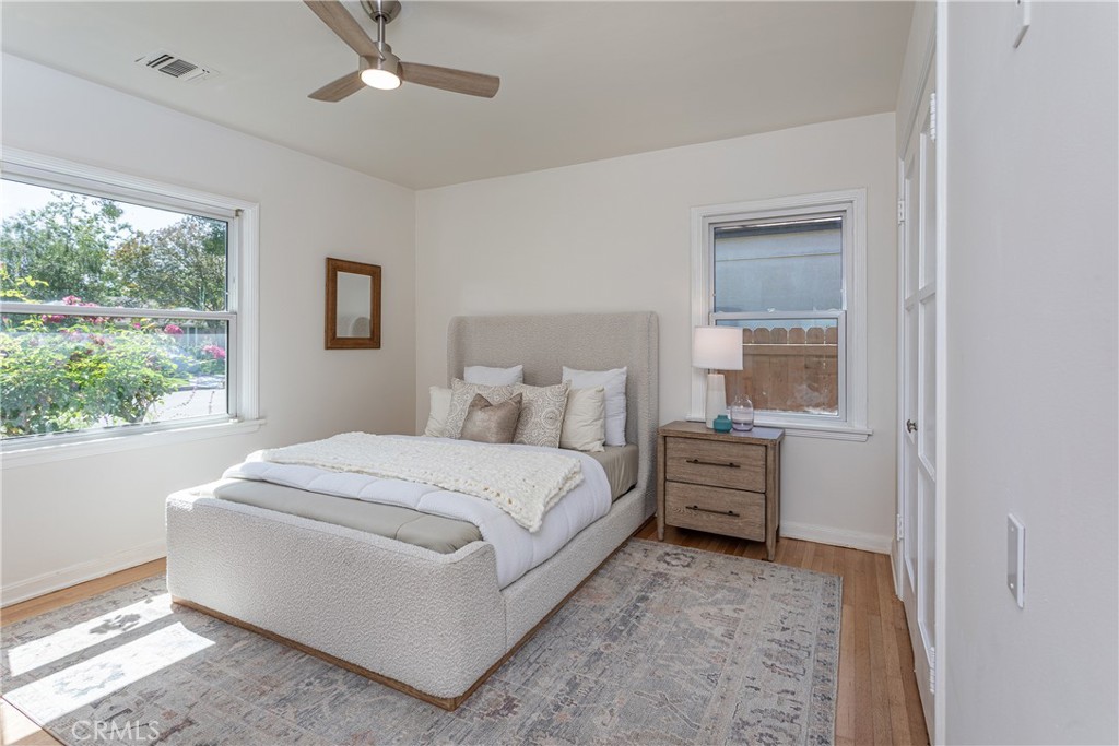 Bedroom with a plush bed, bedside table, and natural light through window