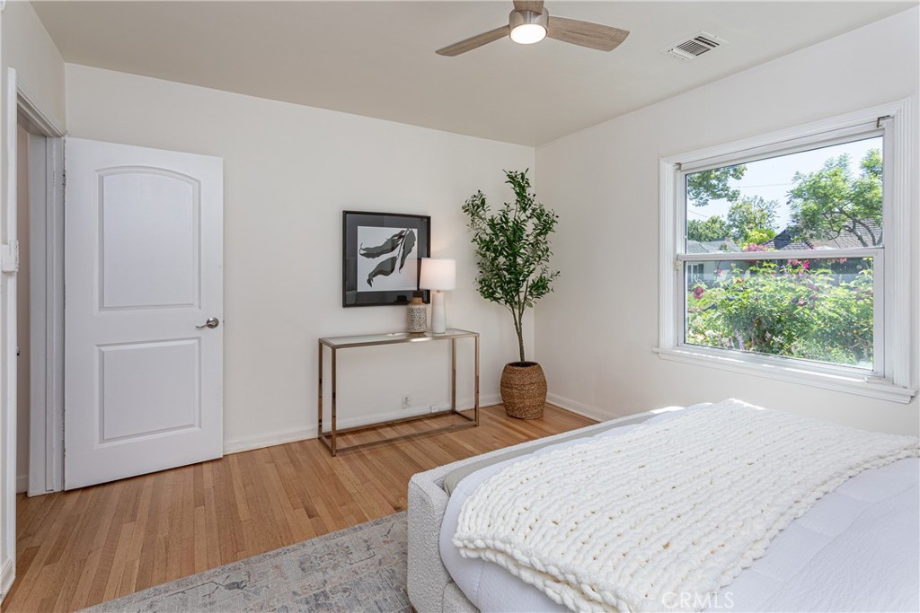 Bright Bedroom with Hardwood Floors and Decor, Featuring Real Estate Listings