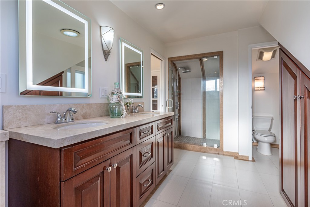 Modern Bathroom with Wooden Cabinets and Glass-Enclosed Shower in Real Estate Listing