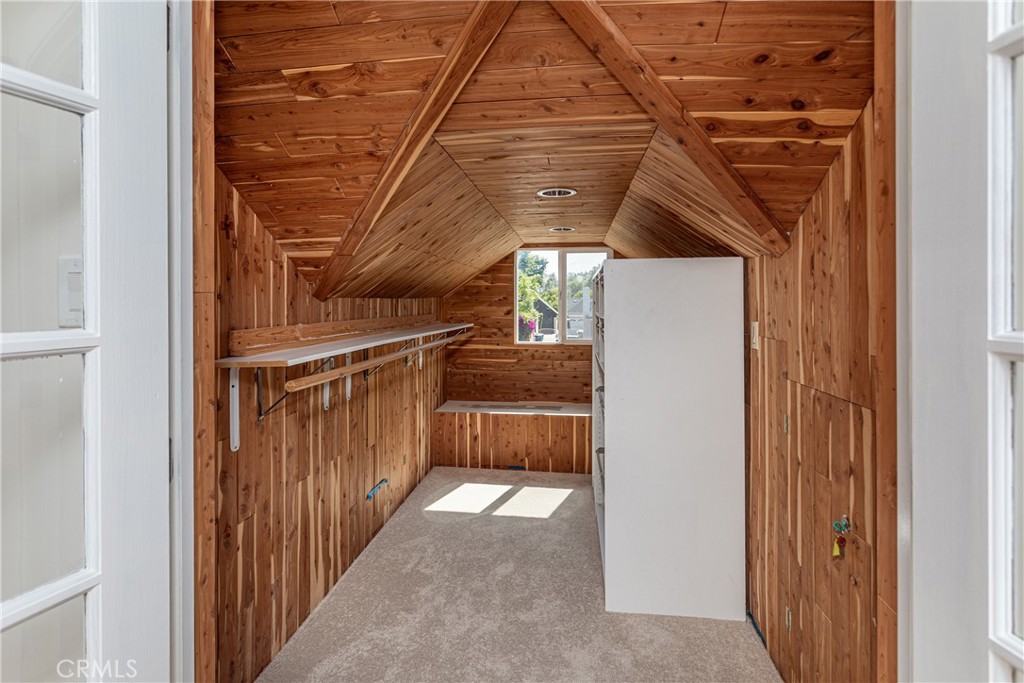 Wood Paneled Room With Sloped Ceiling and Large Window in Real Estate Listing
