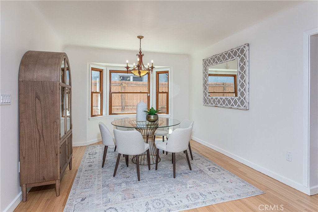 Dining Room with Glass Table, Elegant Chairs, and Large Window in Real Estate Listing