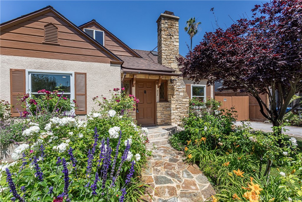 Charming Stone Pathway Leading to Cozy Home Surrounded by Lush Flowers