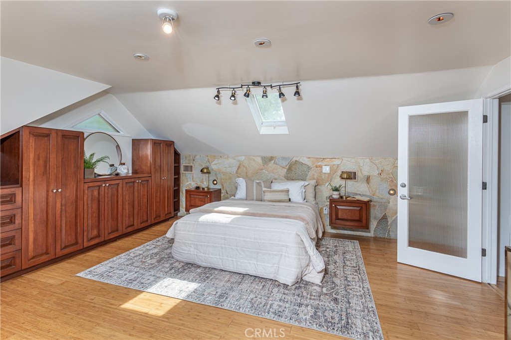 Spacious Bedroom with Wooden Furniture and Natural Stone Accent Wall