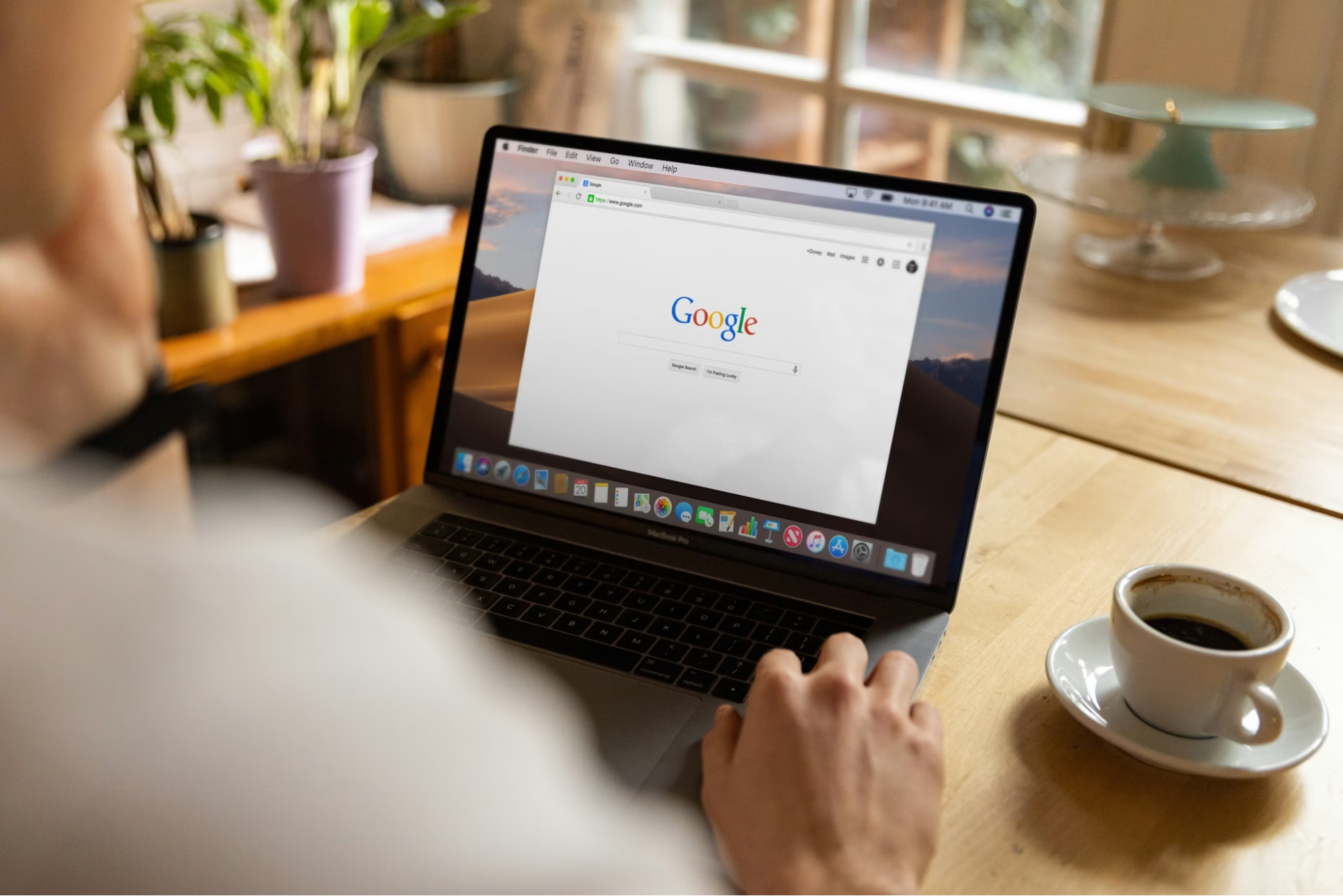 Person Using Laptop to Search Real Estate Listings at Home Office
