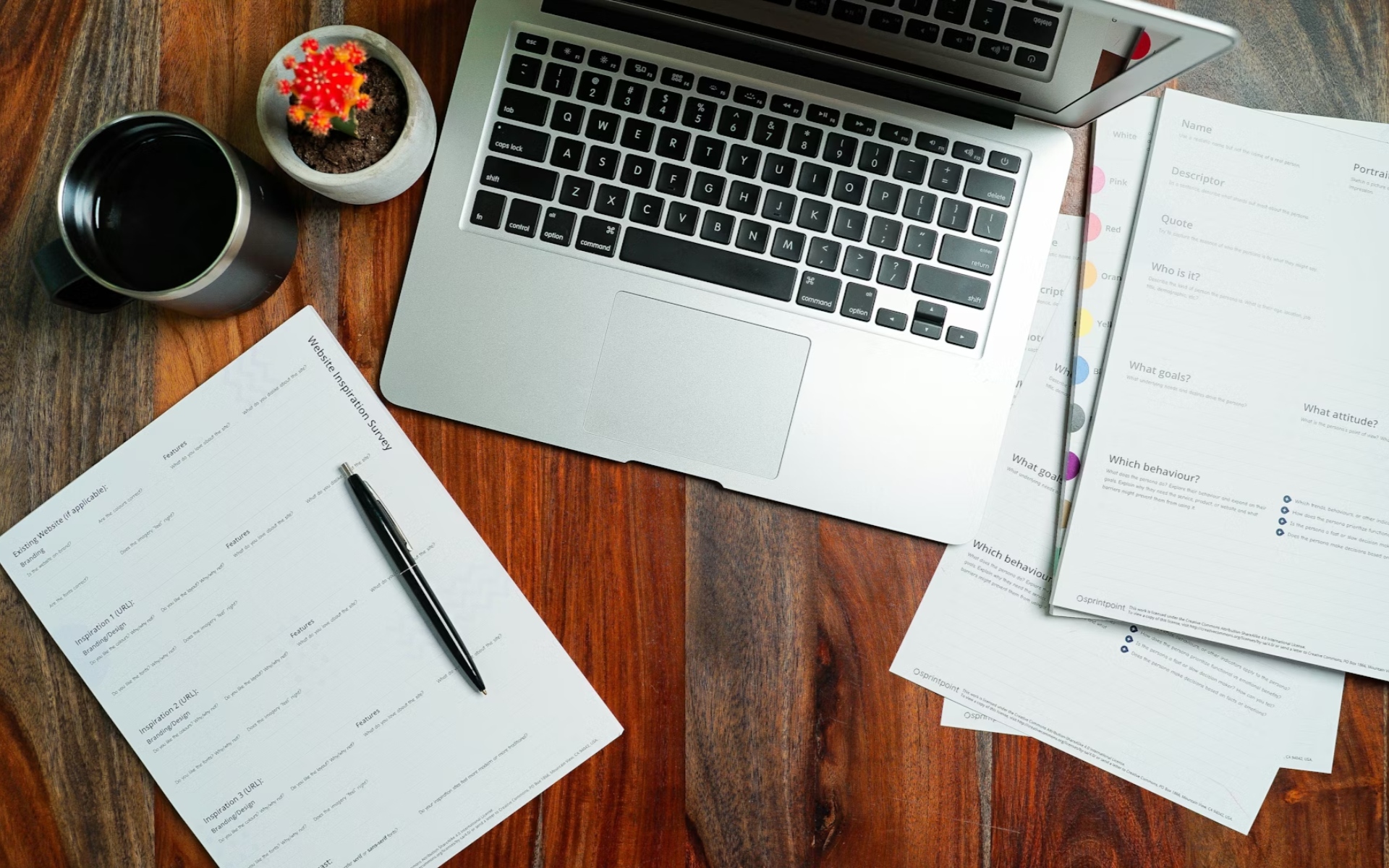 Open Laptop on Wooden Desk with Real Estate Listings and Coffee Cup