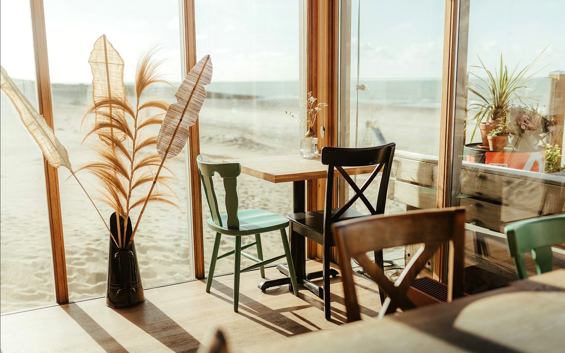 Cozy Beachfront Coffee Shop with Wooden Chairs and Sunlit Windows